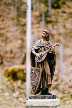 Elinde müzik aleti olan bir gencin bronz heykeli..