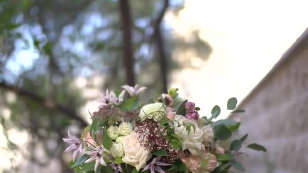 Boeket van roze en crème rozen, eucalyptus twijgen, witte dahlia 's en delicate paarse bloemen in een witte vaas op de tafel — Stockvideo