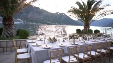 Kotor Körfezi 'ndeki iskelede çiçeklerle, şamdanlarla ve genç narlarla süslenmiş bir düğün yemeğinde bir masa.