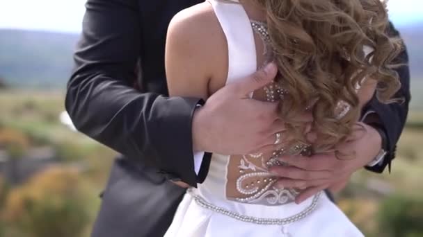 Pengantin pria memeluk pengantin wanita dan dengan lembut membelai punggungnya dengan tangannya — Stok Video