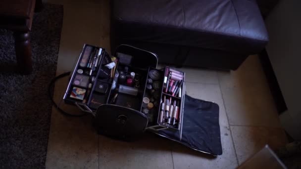 Un estuche con un conjunto de cosméticos de maquillaje profesional permanece abierto en una habitación de hotel durante la preparación para la ceremonia de boda — Vídeo de stock