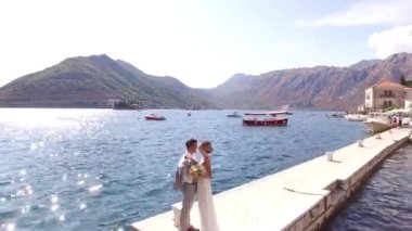 Gelin ve damat rıhtımda durup sarılıyorlar..