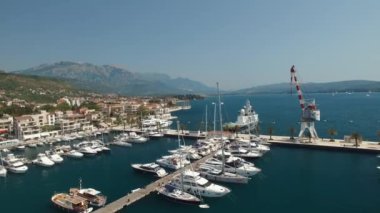 Tivat 'taki Porto Karadağ marinası, rıhtımdaki yatlar, vinç ve otel kompleksi manzarası 