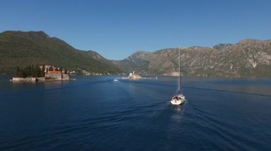 Kotor Körfezi 'nde onlara yakın yüzen Perast adaları ve yatlar görünüyor. 