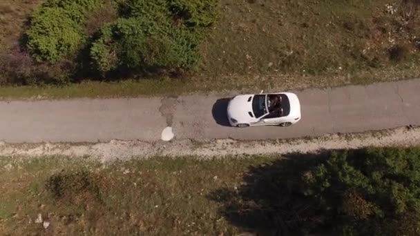 A white convertible drives along the road on Mount Lovcen, top view — Stock Video