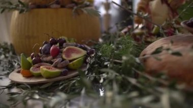 Düğün büfesi peynirli kek aperatifi, meyveler, fındıklar ve yeşillikler, zeytin dallarıyla süslenmiş.
