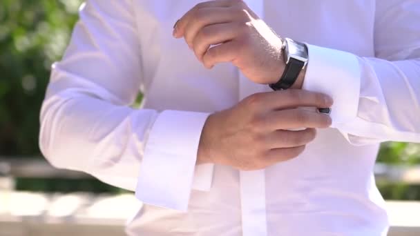 Een man zet een horloge op tijdens de voorbereiding van een huwelijksceremonie — Stockvideo