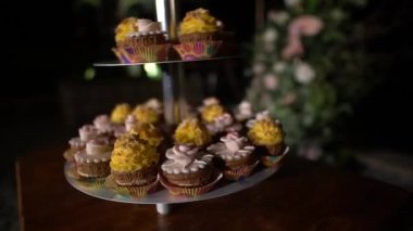 Şenlikli bir ziyafette sarı ve pembe kremayla süslenmiş çöreklerle ayakta durun. 