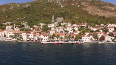 Eski Perast kasabasının manzarası, dağlar, armut ve yakınındaki tekneler. 
