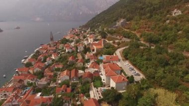 Eski Perast kasabasını, dağları, adaları ve yakınlarındaki tekneleri görebiliriz.
