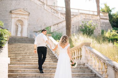 Gelin ve damat Prcanj 'daki Kutsal Bakire Meryem Kilisesi' nin antik merdivenlerinden tırmanıyor.