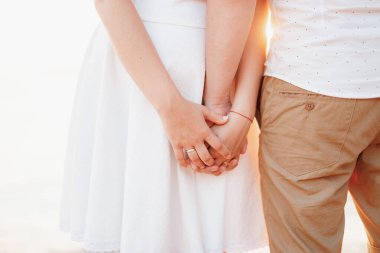 İki aşık, erkek ve kadın yan yana durur ve el ele tutuşurlar, yakın plan. 