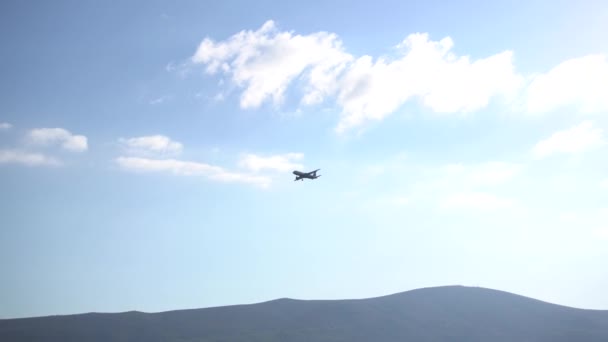 Zicht op het vliegtuig dat over de berg vliegt tussen de wolken — Stockvideo