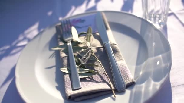 Talíř, příbory a ubrousek na slavnostním stole, zdobené olivovým potahem — Stock video