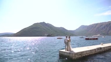 Gelin ve damat rıhtımda birbirlerine sarılıyorlar. 