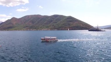 Bir turist teknesi Kotor Körfezi 'nin ortasında yelken açıyor.