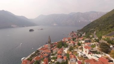 Eski Perast kasabasını, dağları, adaları ve yakınlarındaki tekneleri görebiliriz.