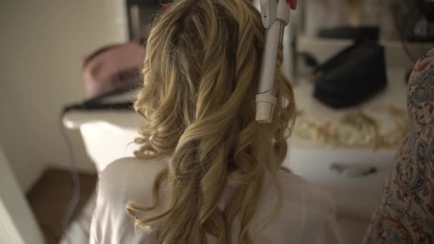 Μια γυναίκα φτιάχνει τα μαλλιά της και κουλουριάζεται προετοιμάζοντας το γάμο.. — Αρχείο Βίντεο