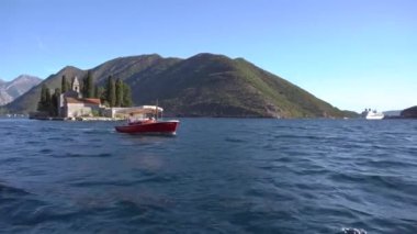 Kotor Körfezi 'ndeki Rocks Adası' ndaki hanımefendiye bir turist teknesi geliyor. 