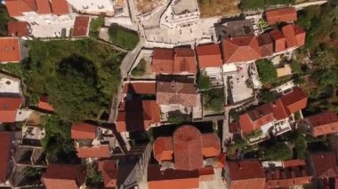 Eski Perast kasabasının hava manzaralı binaları, dağları, denizi, armudu ve yakınındaki tekneleri. 