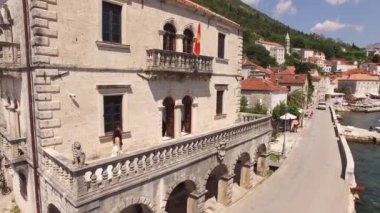 Gelin ve damat Perast 'taki eski bir binanın geniş balkonunda yürüyorlar. 