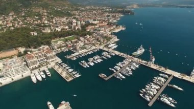 Tivat 'taki Porto Karadağ marinası, rıhtımdaki yat ve tekneler, vinç ve otel kompleksi manzarası