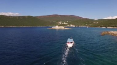 Mamula adası yakınlarında yelken açan bir turist teknesinin görüntüsü.
