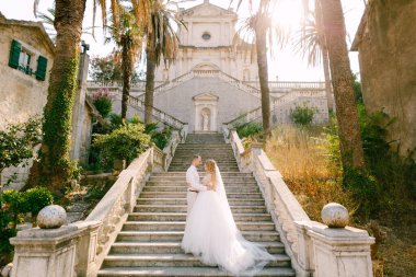  Gelin ve damat Prcanj 'daki Kutsal Bakire Meryem Kilisesi' nin merdivenlerinde el ele tutuşup el ele tutuşuyorlar.
