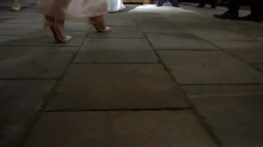 Uzun gece elbiseleri içindeki kadın ve erkeklerin bacakları bir partide ritmik dans ediyorlar. 