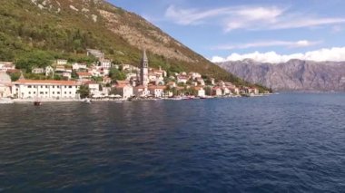 Eski Perast kasabasının manzarası, dağlar, armut ve yakınındaki tekneler. 