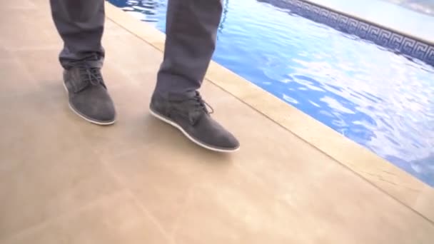 Gambe di un uomo che cammina lungo la piscina, primo piano — Video Stock