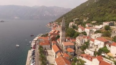 Eski Perast kasabasını, dağları, adaları ve yakınlarındaki tekneleri görebiliriz.