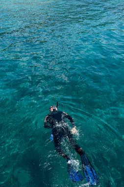 Dalgıç denizde yüzer, en tepede..