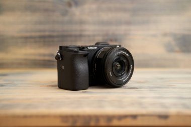 Budva, Karadağ - 15 Mart 2021: Ahşap arkaplan dokusunda 16-50 mm mercekli Sony a6300 kamera. Sony aynasız kamera.