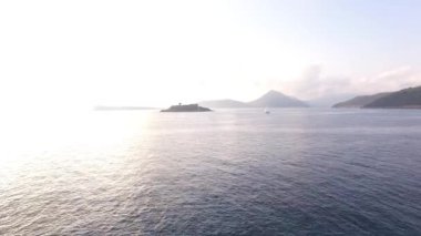 Denizden Karadağ 'ın Mamula adasına manzara, suda güneş parlıyor 