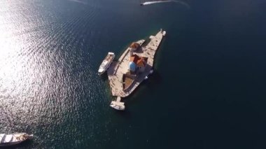 Kayalıklar Adası 'nın en güzel manzarası. Kotor Körfezi' ndeki yat ve turist teknesi. 