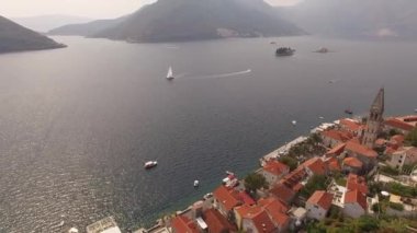 Eski Perast kasabasını, dağları, adaları ve yakınlarındaki tekneleri görebiliriz.
