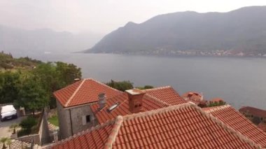 Eski Perast kasabasının manzarası, dağlar, armut ve yakınındaki tekneler. 