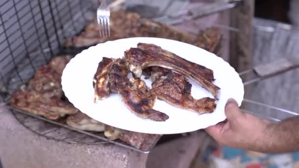 Kocken lägger grillade lamm revben på en tallrik. — Stockvideo