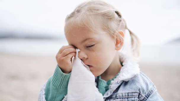 L'enfant essuie les larmes. Une petite fille essuie ses yeux avec une serviette. — Video