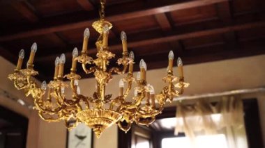 Eski bir villanın içindeki antik bir altın avizesinin yakın çekimi..