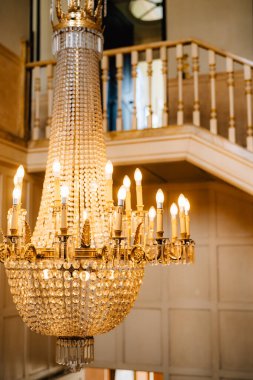 Kolyeleri ve mumları olan büyük bir antika kristal avize..