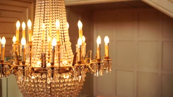Antyczny duży kryształowy żyrandol z wisiorkami i świecami. — Wideo stockowe
