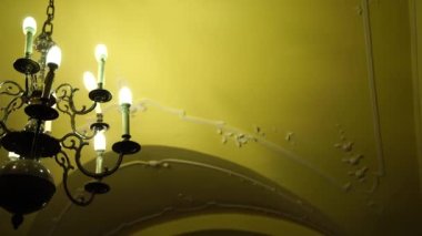 Tavanı ve mum ampulleri olan barok tarzı siyah metal avize..