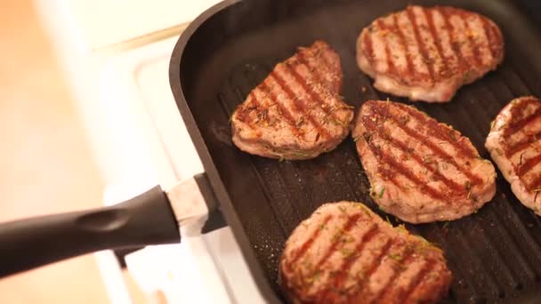 Fresh beef meat on ignited pan, closeup view. Cooking beef steak at frying pan, delicious steaks are fried on a grill pan. — Stock Video