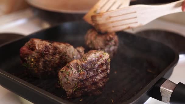 Fresh beef meat on ignited pan, closeup view. Cooking beef steak at frying pan, delicious steaks are fried on a grill pan. — Stock Video