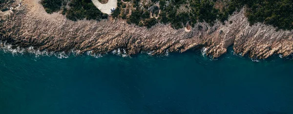 Vista aérea de las olas del mar golpeando rocas en la playa con agua de mar turquesa. Increíble paisaje marino de acantilados rocosos en la costa. Vista aérea de las olas marinas y la fantástica costa rocosa. Mar Mediterráneo. — Foto de Stock