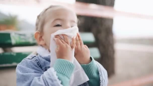 Het kind-meisje zelf veegt haar mond af met een wegwerpservet na het eten. — Stockvideo