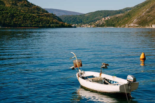 Small wooden boat with a searchlight in the Bay of Kotor.
