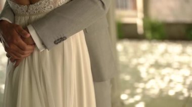 Damat, geline güzel bir elbiseyle sarıldı. Sırtı açık gölgeli bir sokakta. 